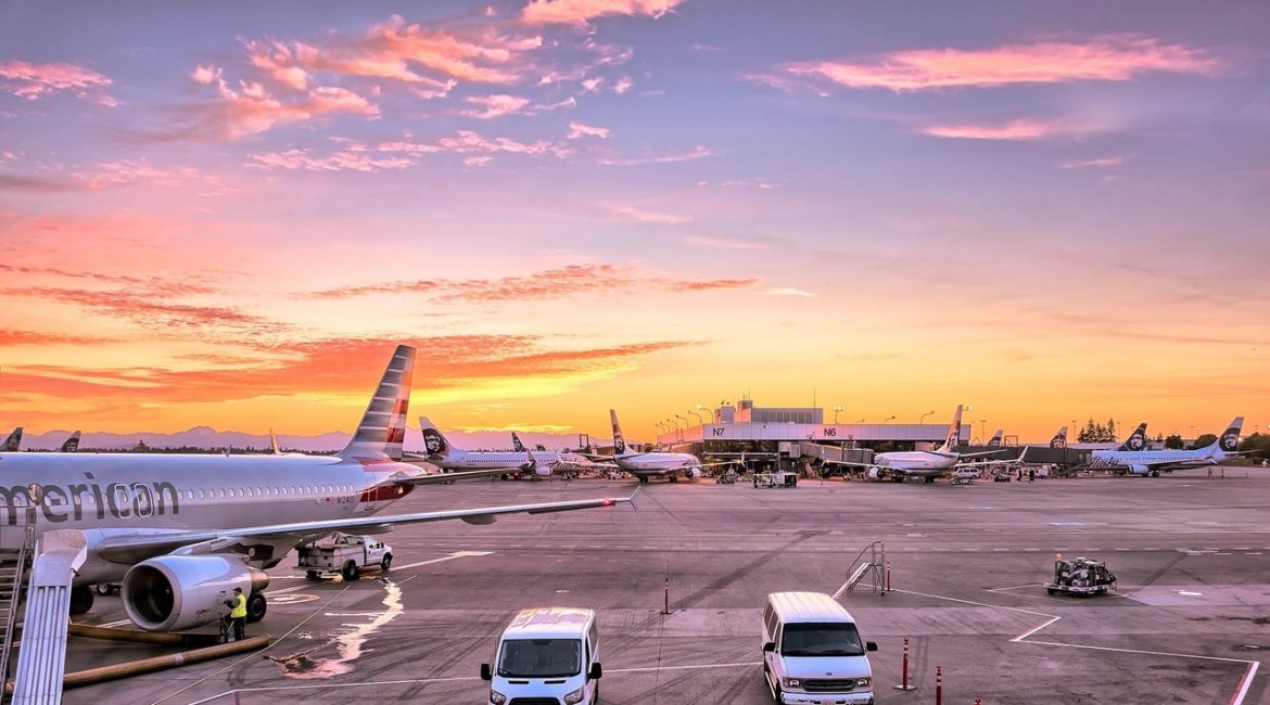 Fly holder i lufthavn i solnedgang