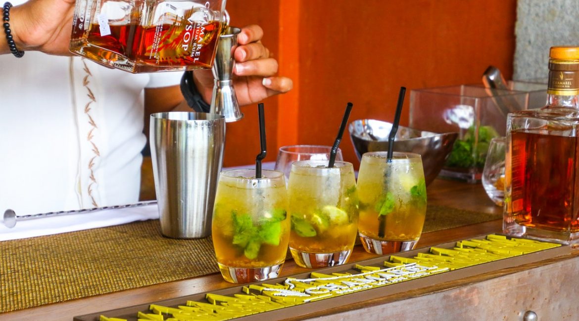 Person laver tropiske drinks i en bar